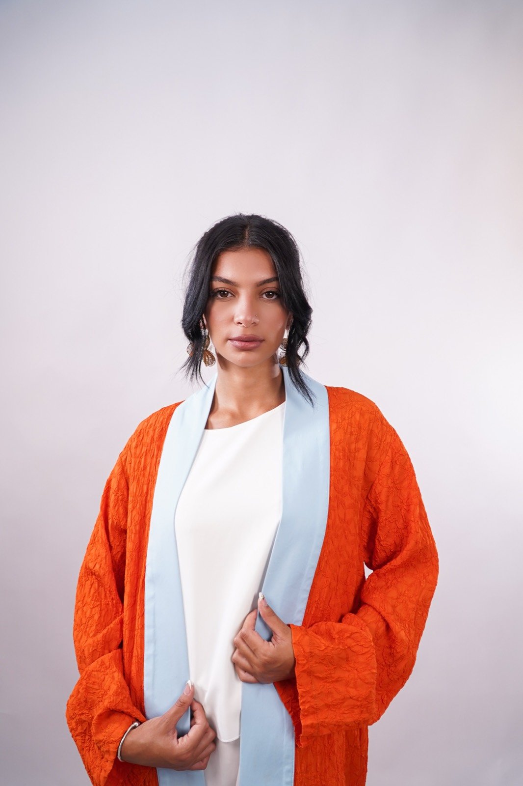Amber Sky open-front robe in burnt orange, waist-up, worn over a white top, from the Le Kanz summer collection